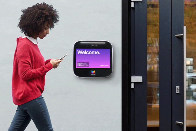 Woman entering building with iApartments + ButterflyMX access control